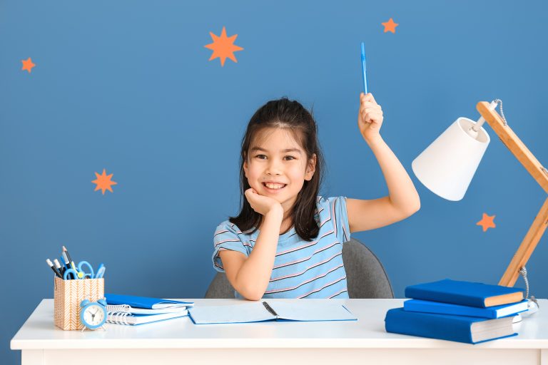 little asian girl doing homework table scaled
